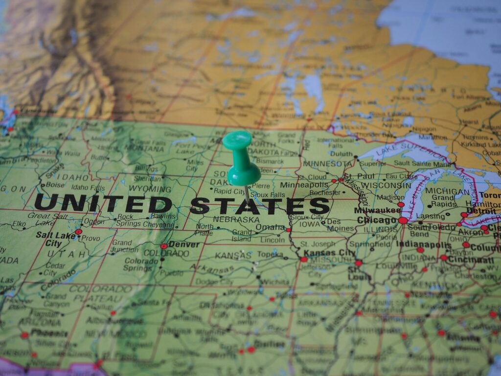 High-angle view of a map featuring the United States with a green pin indicating a specific location.